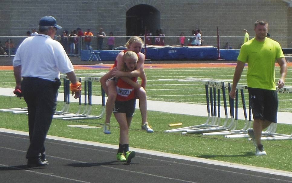 La 13enne Claire porta al traguardo la gemella infortunata durante una gara di 800 metri. Ap